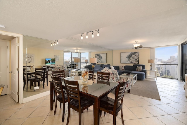 dining space with light tile patterned floors, a healthy amount of sunlight, and a textured ceiling