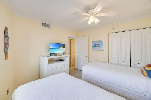 bedroom featuring visible vents, crown molding, ceiling fan, light wood-style floors, and a closet