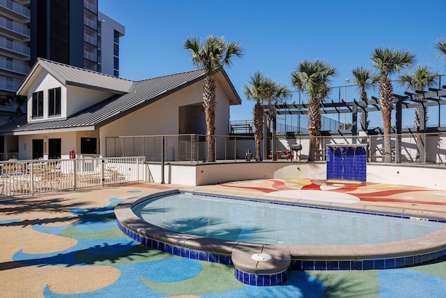 community pool with a jacuzzi, a patio, a pergola, and fence