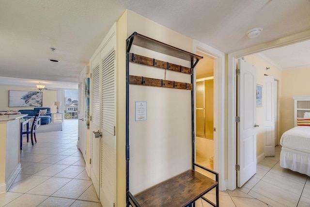 corridor with light tile patterned floors and ornamental molding