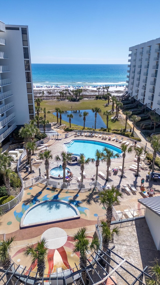 view of swimming pool featuring a view of the beach and a water view