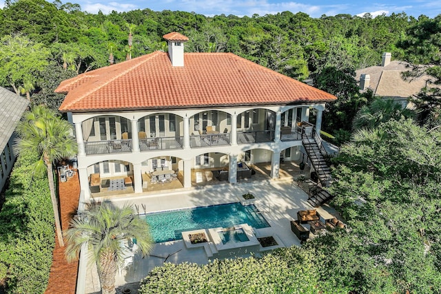 2940 Pine Valley Dr, Miramar Beach, FL 32550 - rear view of house featuring a wooded view, a tile roof, a patio area, and a balcony
