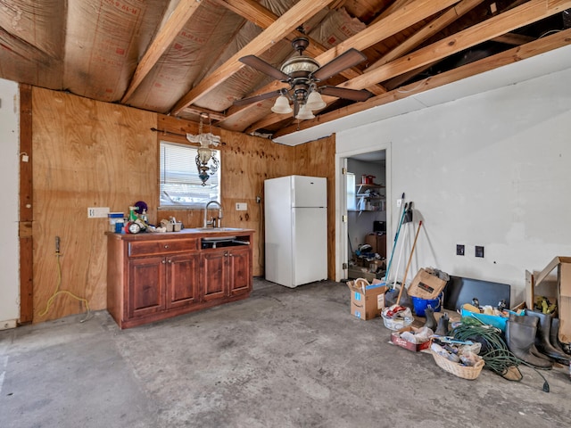 interior space with ceiling fan, unfinished concrete floors, freestanding refrigerator, and a sink