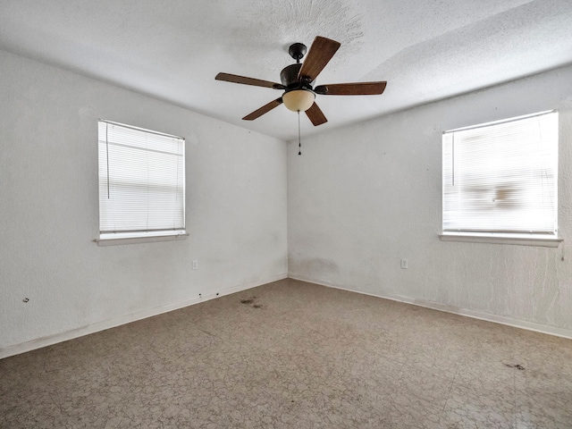 spare room with baseboards, a textured ceiling, and a ceiling fan