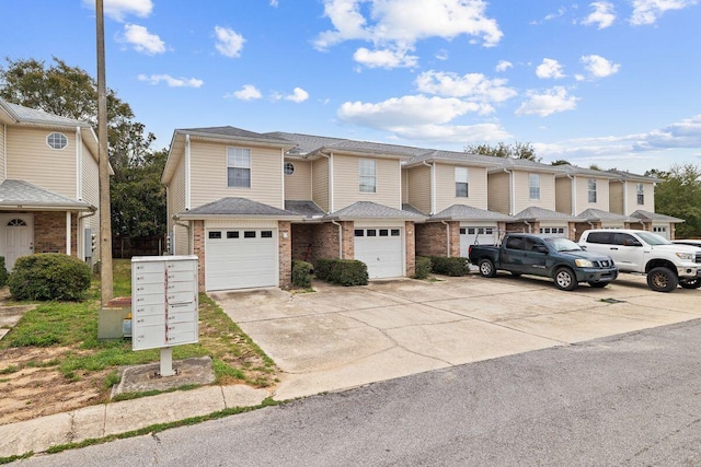 multi unit property featuring a garage, brick siding, and driveway