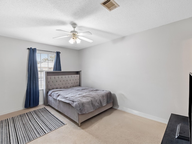 bedroom featuring visible vents, a ceiling fan, a textured ceiling, carpet floors, and baseboards