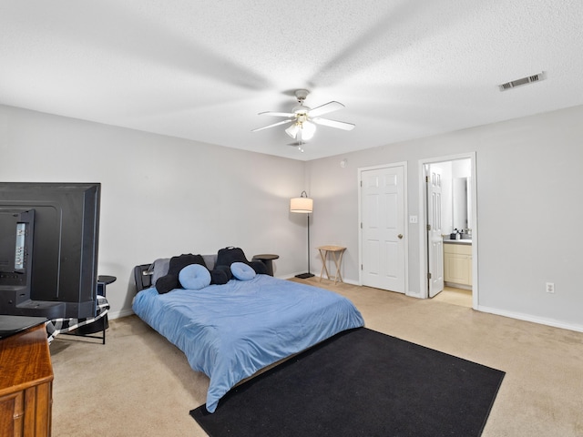 bedroom with a textured ceiling, a ceiling fan, baseboards, and light carpet