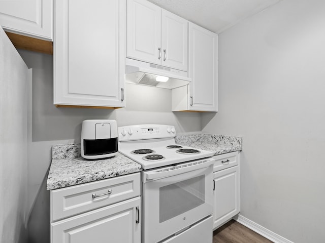 kitchen featuring under cabinet range hood, electric range, baseboards, and white cabinetry