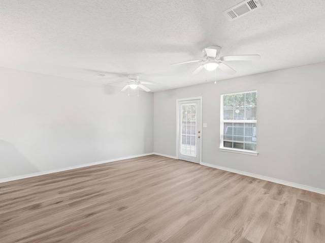 empty room featuring visible vents, baseboards, light wood-type flooring, and ceiling fan