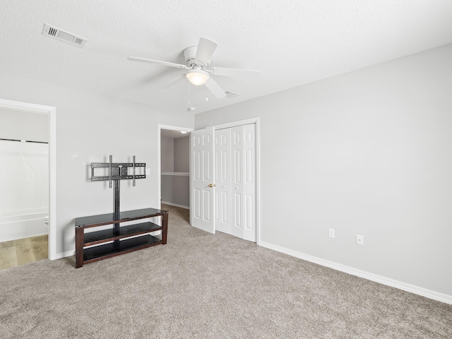 interior space with visible vents, a textured ceiling, a closet, carpet flooring, and baseboards