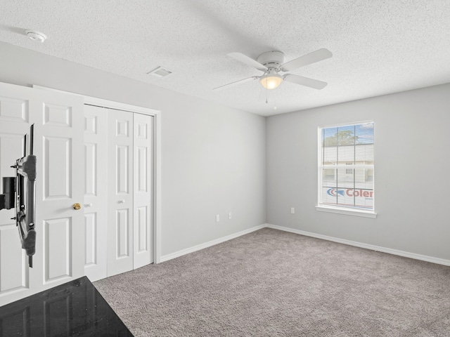 unfurnished bedroom featuring a closet, baseboards, ceiling fan, and carpet flooring