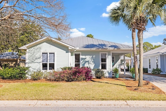 view of front of house with an attached carport, a front lawn, driveway, and metal roof