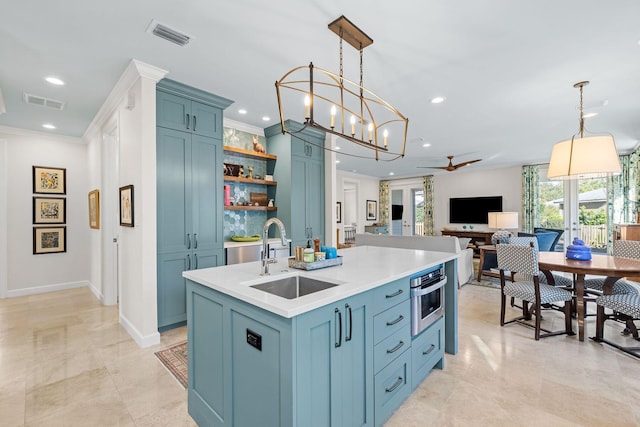 kitchen featuring a sink, blue cabinetry, plenty of natural light, and light countertops