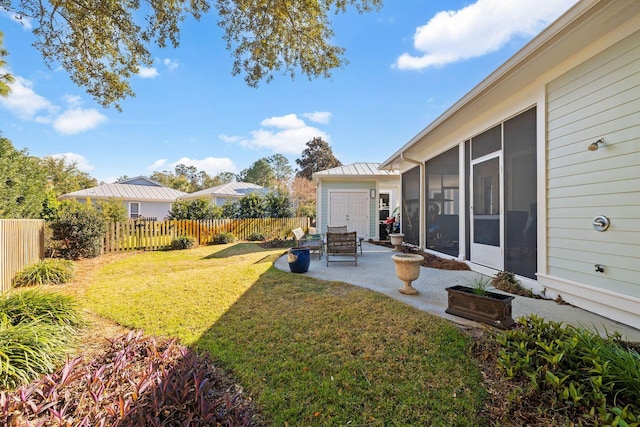 view of yard with fence, a patio, and a sunroom