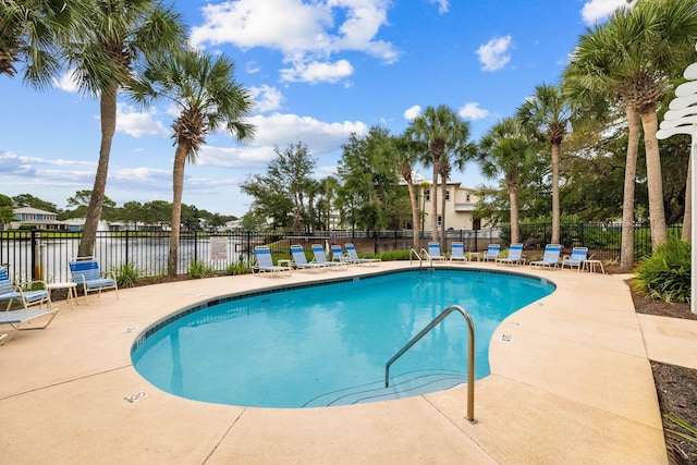 community pool with a patio area and fence