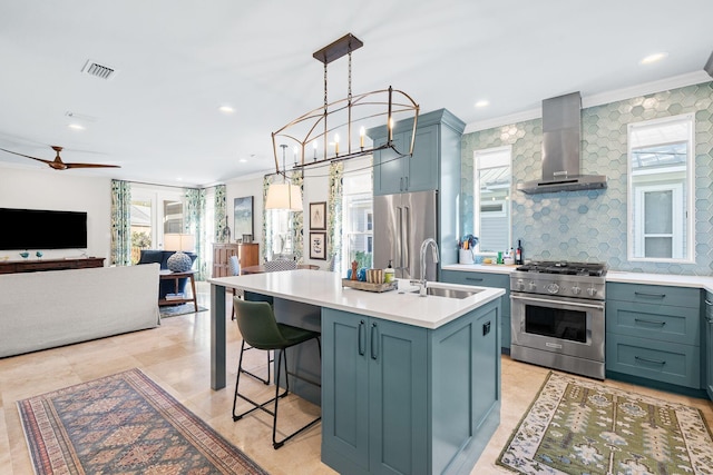 kitchen featuring visible vents, high quality appliances, a sink, wall chimney exhaust hood, and light countertops