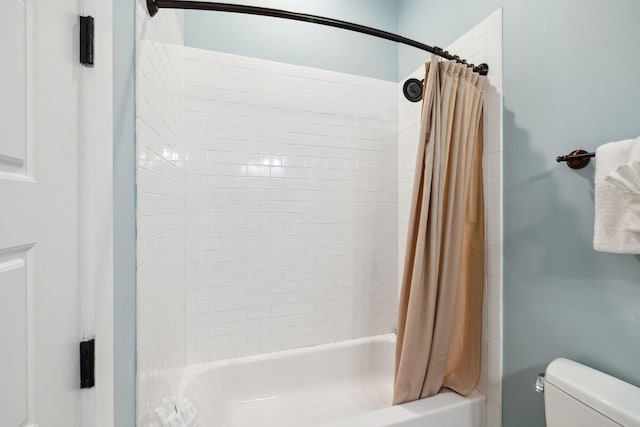 bathroom with shower / bath combination with curtain and toilet