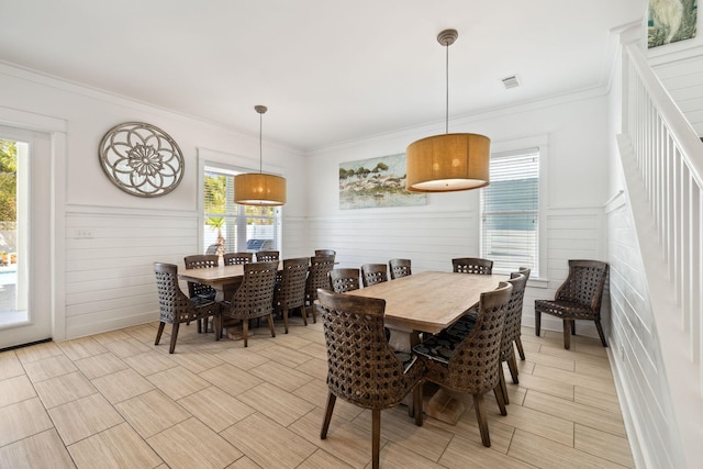 dining space with a healthy amount of sunlight, visible vents, and ornamental molding