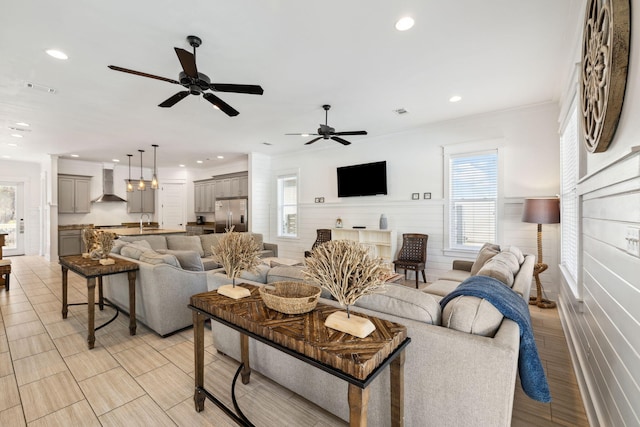 living room featuring visible vents, light wood finished floors, recessed lighting, ornamental molding, and ceiling fan