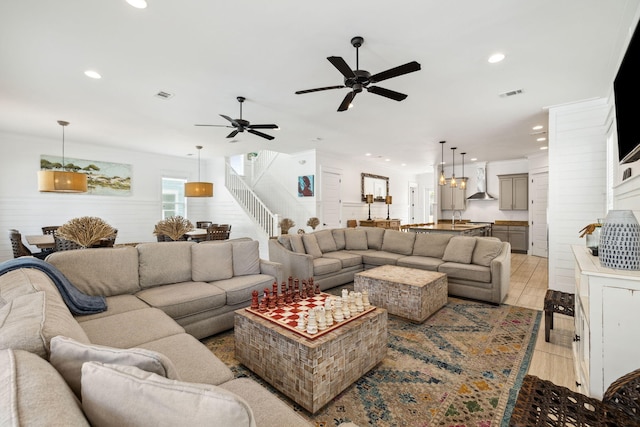 living area featuring recessed lighting, visible vents, a ceiling fan, and stairs