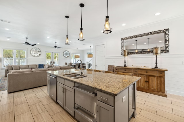 kitchen featuring light stone counters, gray cabinets, visible vents, and a sink