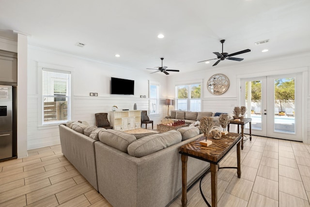 living room with visible vents, plenty of natural light, wainscoting, and crown molding