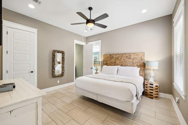 bedroom featuring baseboards, multiple windows, and ceiling fan