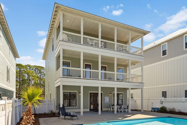 back of house featuring a patio area, a fenced in pool, a balcony, and fence