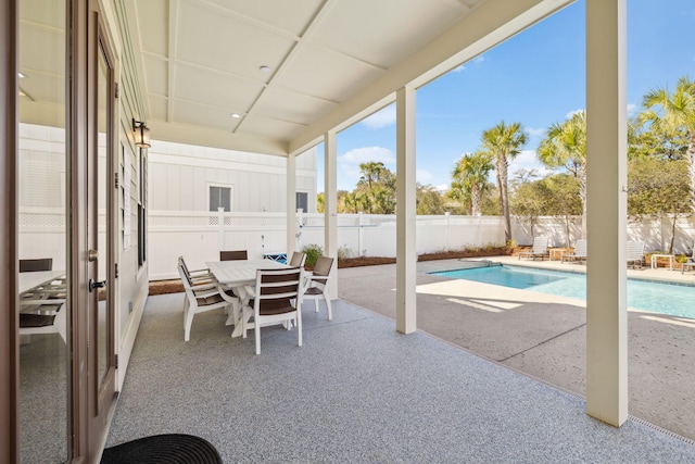 exterior space featuring a patio, outdoor dining area, a fenced in pool, and a fenced backyard