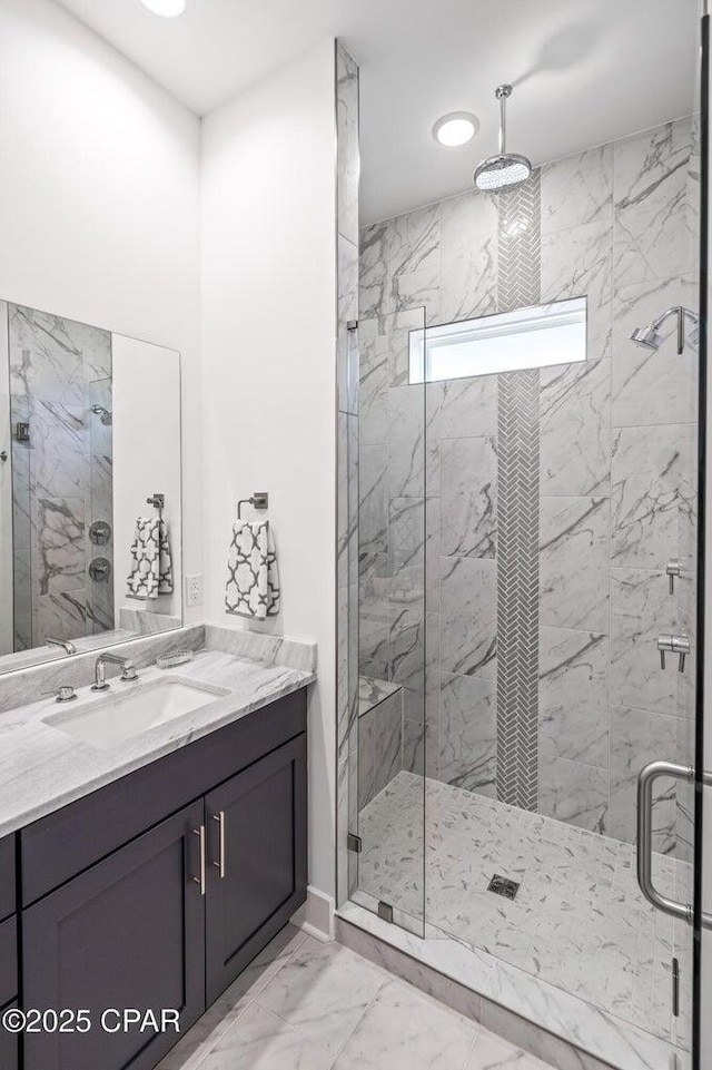 full bath with a marble finish shower, recessed lighting, marble finish floor, and vanity
