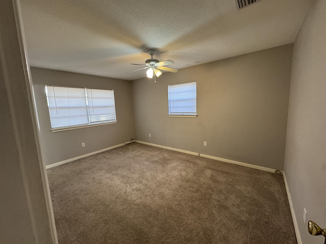 spare room with baseboards, carpet floors, a textured ceiling, and ceiling fan