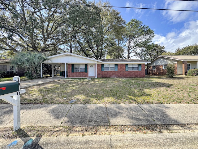 ranch-style house with brick siding, an attached carport, concrete driveway, and a front lawn