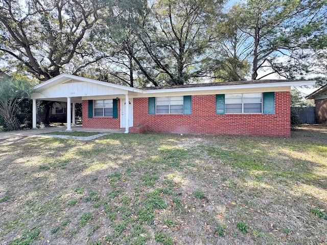 ranch-style house with an attached carport, brick siding, a front lawn, and driveway