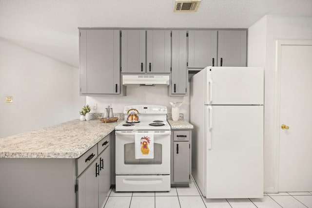 kitchen with visible vents, under cabinet range hood, gray cabinets, a peninsula, and white appliances