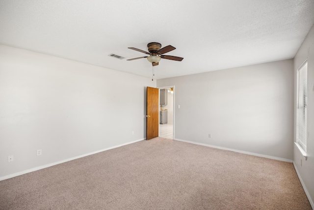 empty room featuring baseboards, visible vents, ceiling fan, a textured ceiling, and carpet flooring