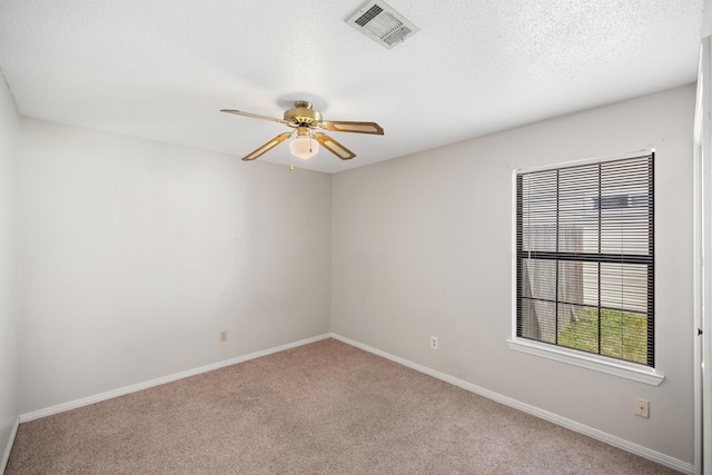 unfurnished room featuring visible vents, a ceiling fan, a textured ceiling, carpet, and baseboards