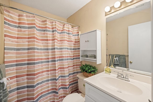 bathroom featuring vanity, curtained shower, toilet, and a textured ceiling