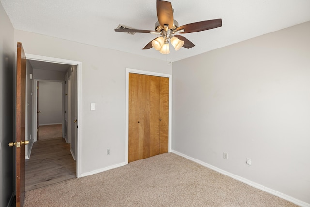 unfurnished bedroom featuring carpet flooring, a ceiling fan, baseboards, and a closet