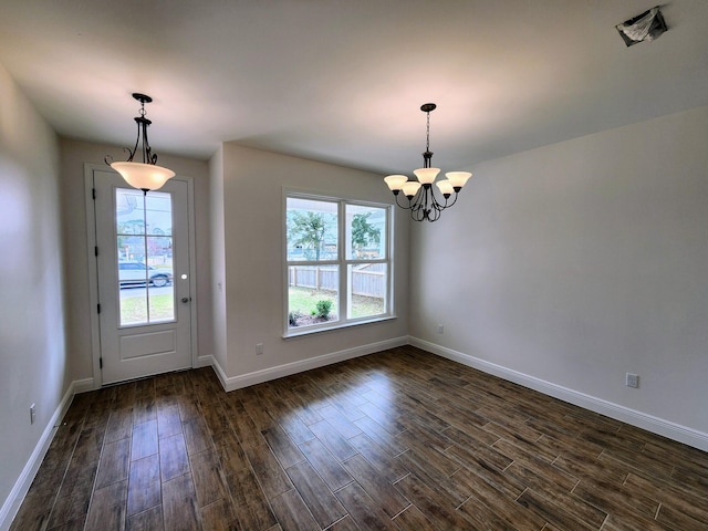 unfurnished dining area featuring a notable chandelier, baseboards, dark wood-style flooring, and a wealth of natural light