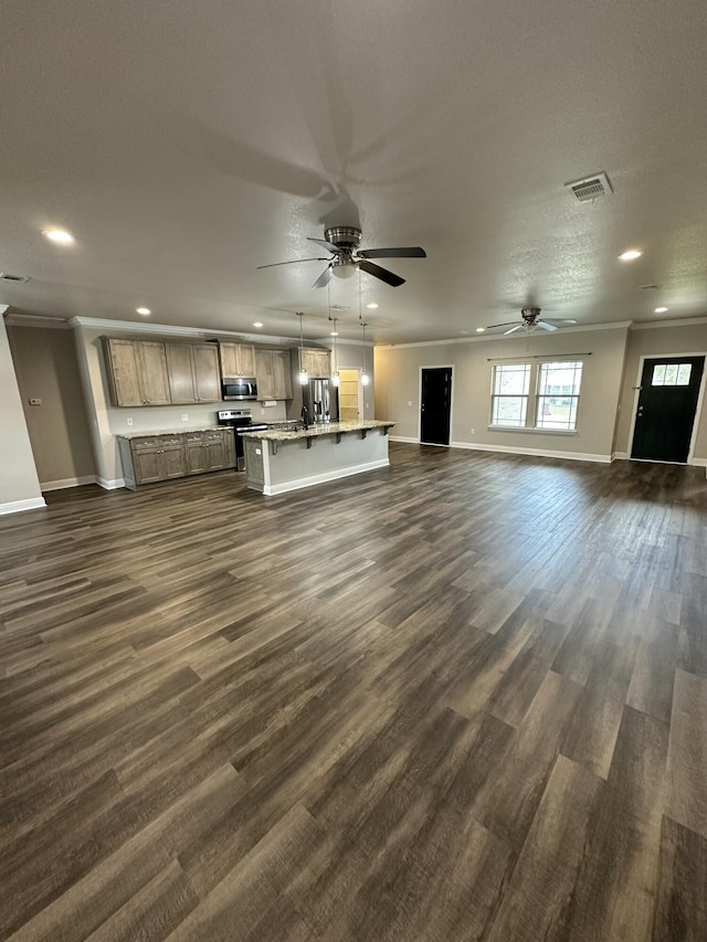 unfurnished living room with crown molding, dark wood-style floors, visible vents, and baseboards