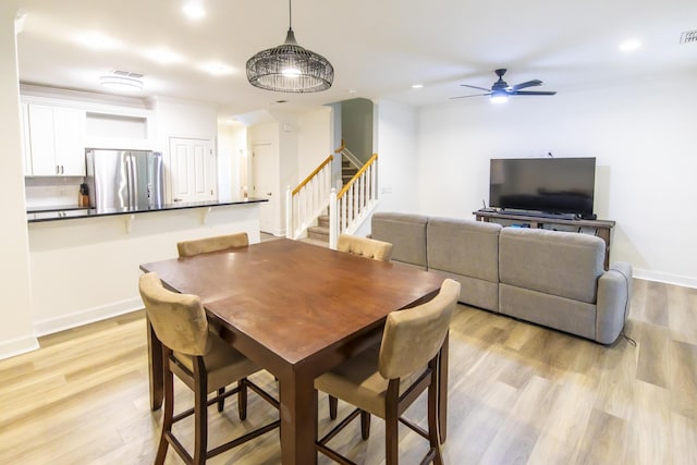 dining area featuring a ceiling fan, baseboards, recessed lighting, stairs, and light wood-type flooring