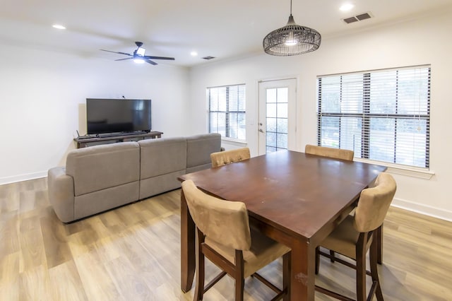 dining area featuring visible vents, a healthy amount of sunlight, light wood-style flooring, and ceiling fan