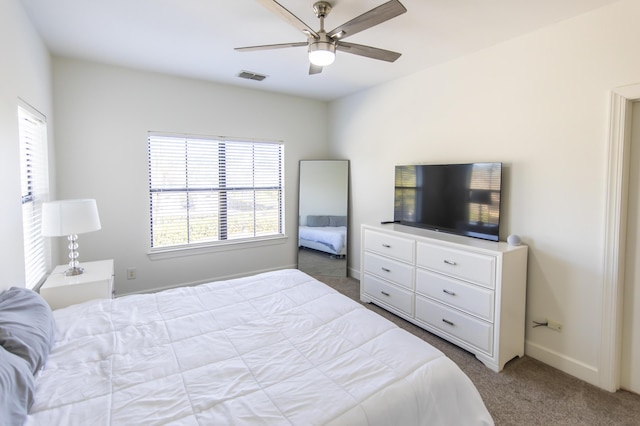 carpeted bedroom with baseboards, visible vents, and ceiling fan