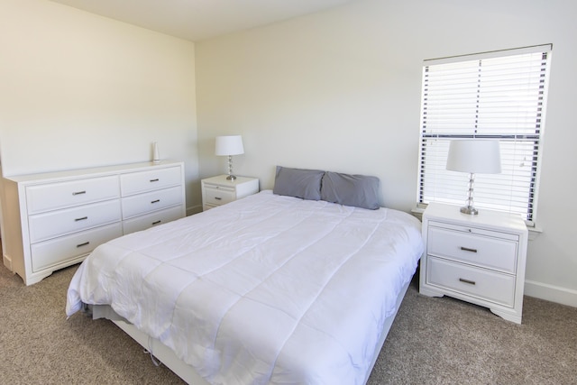 bedroom with baseboards and carpet