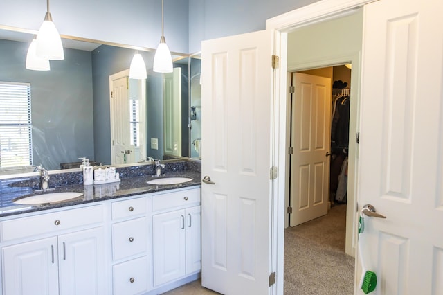 bathroom with a sink, a spacious closet, and double vanity