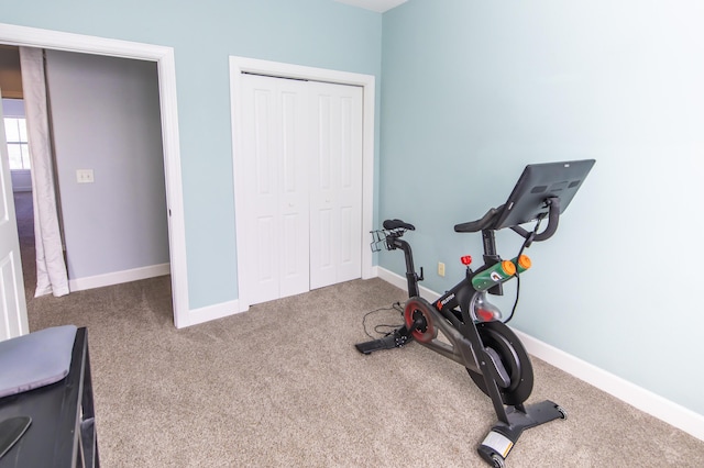 workout area featuring carpet and baseboards