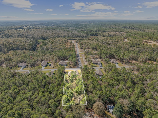 birds eye view of property featuring a view of trees