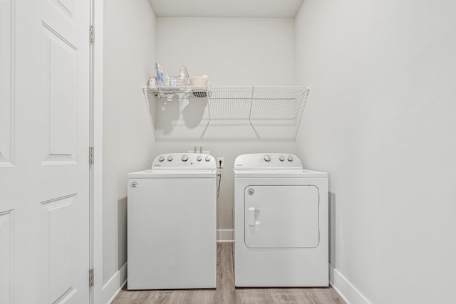 washroom with laundry area, independent washer and dryer, baseboards, and wood finished floors