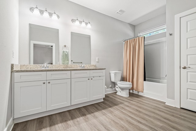 full bath with visible vents, toilet, double vanity, shower / tub combo, and wood finished floors