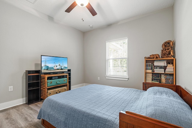 bedroom featuring light wood-type flooring, baseboards, and ceiling fan